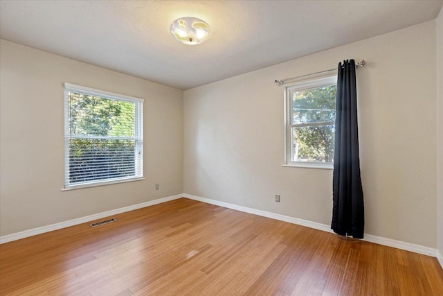 empty room featuring hardwood / wood-style flooring and a healthy amount of sunlight