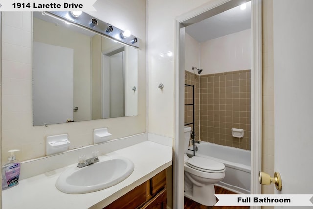 bathroom featuring toilet, bathtub / shower combination, and vanity