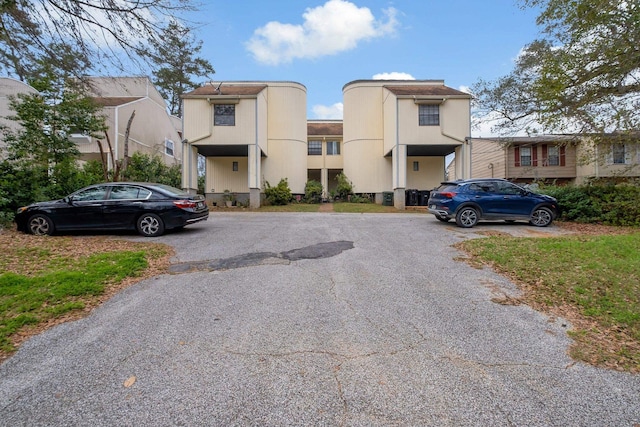 view of building exterior featuring a residential view and uncovered parking