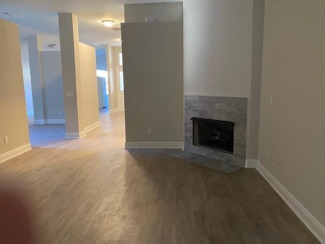 unfurnished living room featuring a fireplace and wood-type flooring