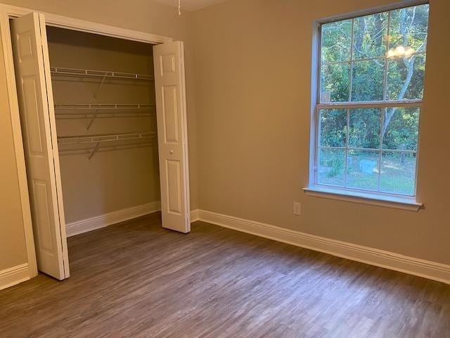 unfurnished bedroom featuring dark hardwood / wood-style floors and a closet