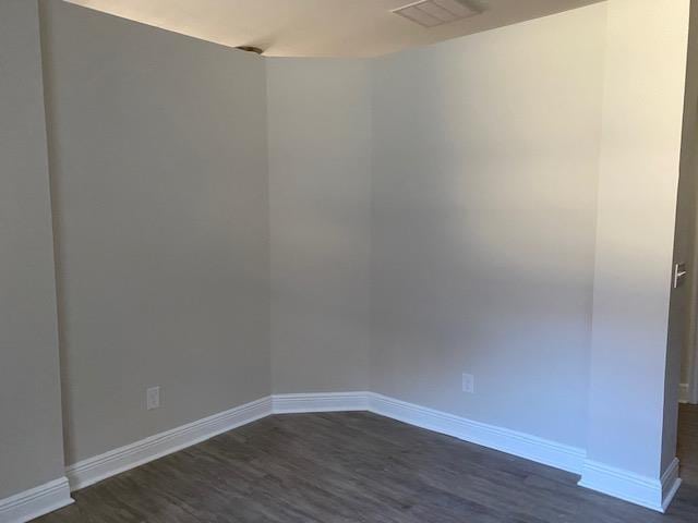 empty room with dark hardwood / wood-style flooring