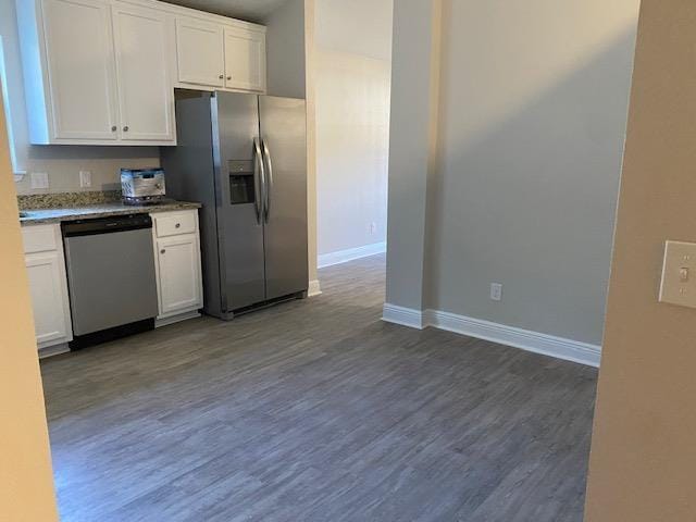 kitchen with dark hardwood / wood-style flooring, stainless steel appliances, and white cabinets