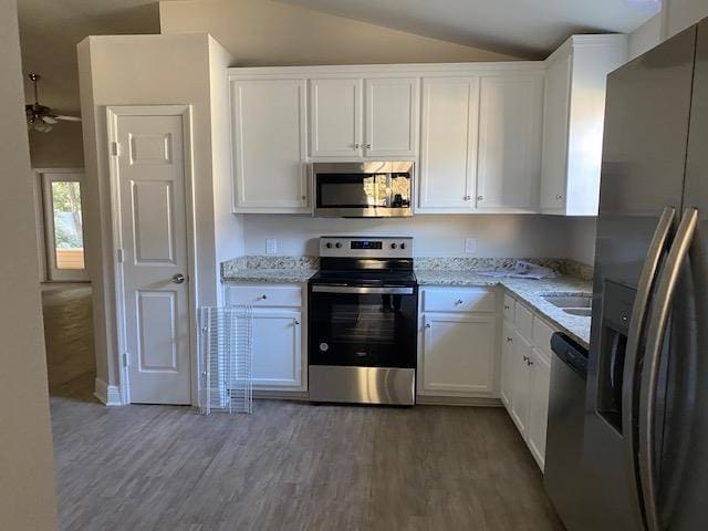 kitchen featuring white cabinetry, appliances with stainless steel finishes, and light stone counters