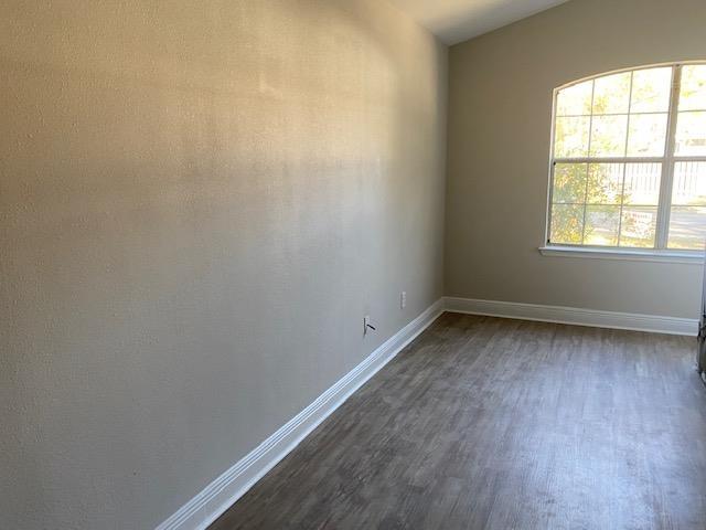 spare room with lofted ceiling and dark hardwood / wood-style floors