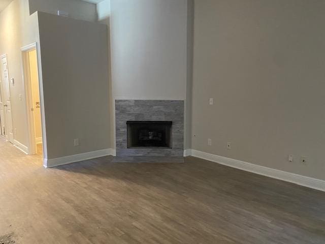 unfurnished living room with a tile fireplace and dark hardwood / wood-style flooring