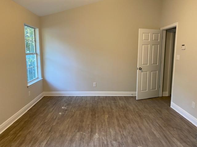 spare room with dark wood-type flooring