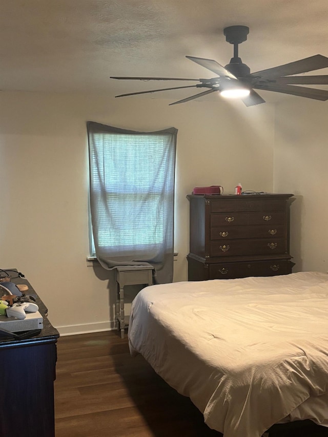 bedroom with baseboards, dark wood finished floors, and a ceiling fan