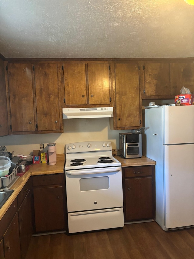 kitchen featuring white appliances, light countertops, under cabinet range hood, and dark wood-style flooring