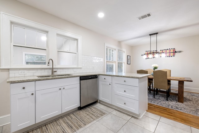 kitchen featuring white cabinetry, pendant lighting, sink, and stainless steel dishwasher