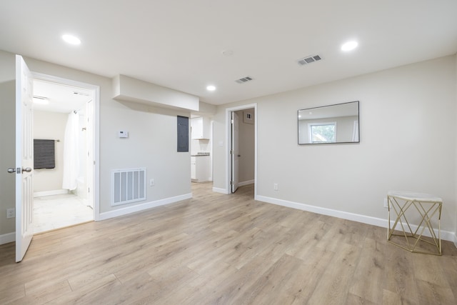 unfurnished living room with light hardwood / wood-style floors and electric panel