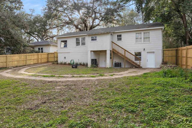 back of house with a yard and central AC