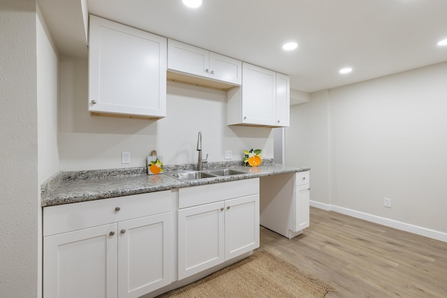 kitchen featuring white cabinetry, sink, and light hardwood / wood-style floors