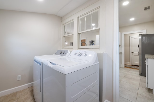 laundry area with light tile patterned flooring and washing machine and clothes dryer