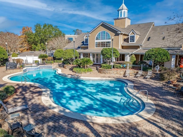 view of pool with french doors and a patio area