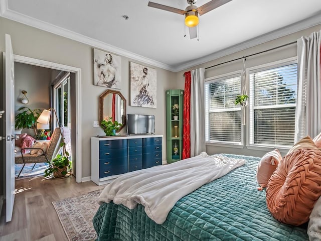 bedroom featuring hardwood / wood-style floors, crown molding, and ceiling fan