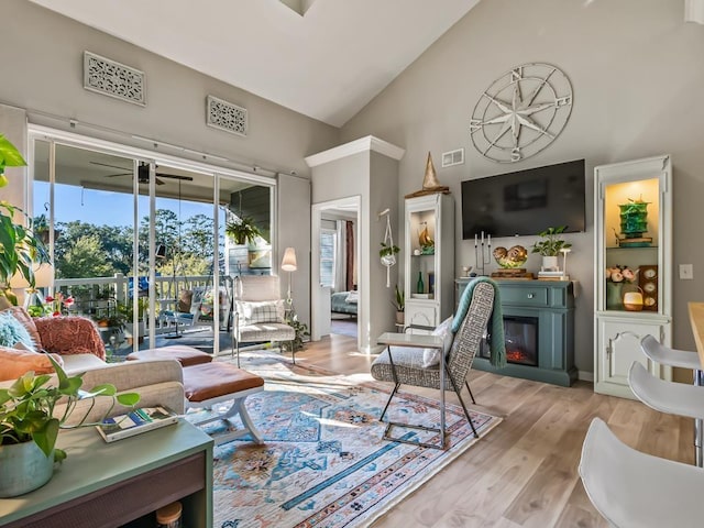 living room with high vaulted ceiling and light hardwood / wood-style floors