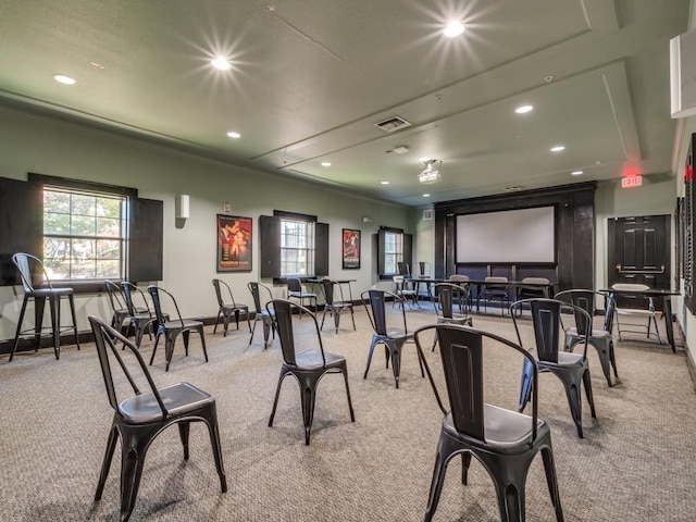 carpeted home theater room with ornamental molding