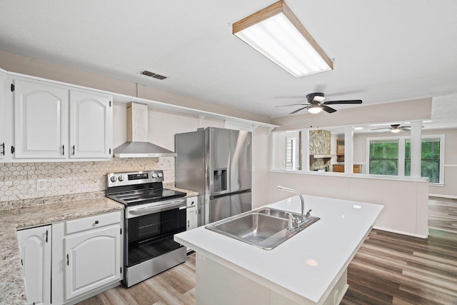 131 Alma Yates St, Quincy, FL 32351 - kitchen featuring stainless steel appliances, wall chimney range hood, a sink, and light wood-style flooring