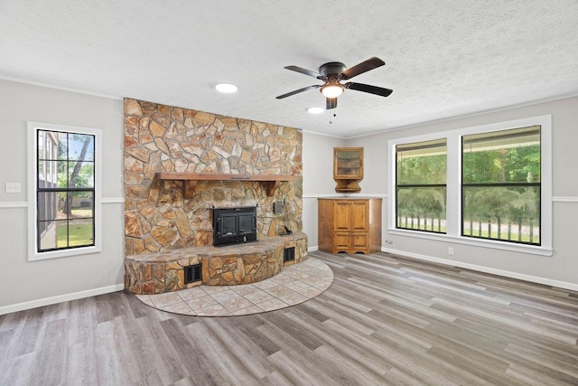 131 Alma Yates St, Quincy, FL 32351 - unfurnished living room featuring wood finished floors, ceiling fan, a textured ceiling, a wood stove, and baseboards