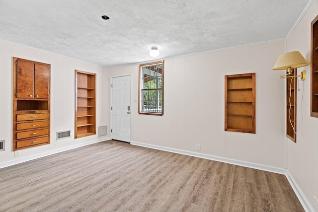 131 Alma Yates St, Quincy, FL 32351 - empty room with built in shelves, a textured ceiling, wood finished floors, baseboards, and crown molding