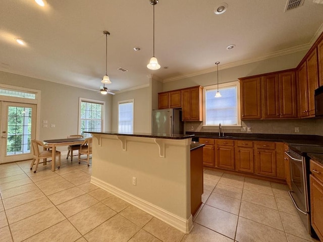 5672 Burnside Cir, Tallahassee, FL 32312 - kitchen with appliances with stainless steel finishes, light tile patterned floors, a kitchen bar, brown cabinetry, and backsplash