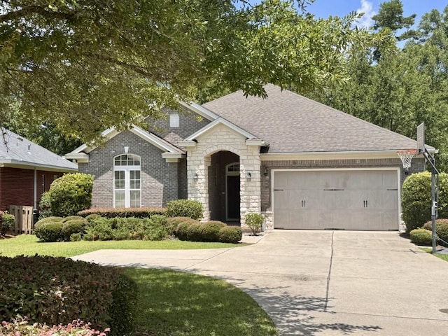 5672 Burnside Cir, Tallahassee, FL 32312 - view of front of home featuring driveway, a shingled roof, a garage, stone siding, and brick siding