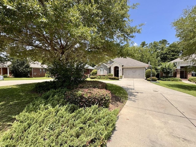 5672 Burnside Cir, Tallahassee, FL 32312 - view of property hidden behind natural elements featuring concrete driveway, a garage, and a front yard