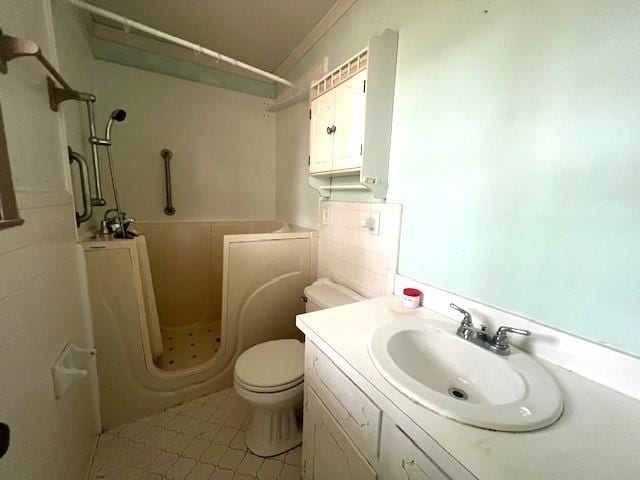 bathroom featuring ornamental molding, vanity, toilet, and a shower