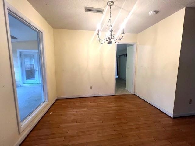 unfurnished dining area featuring dark wood-type flooring and a chandelier