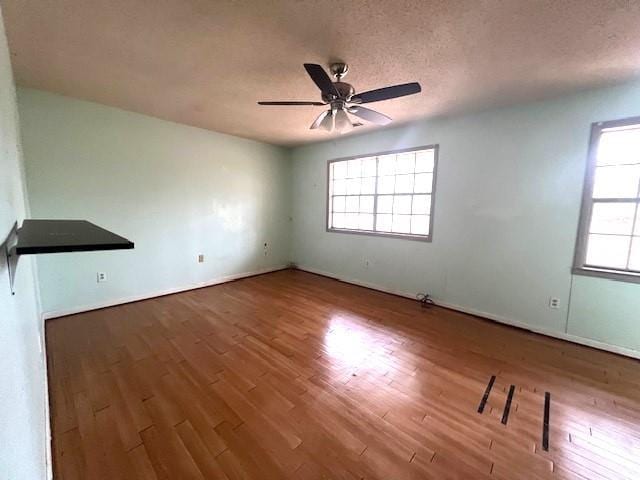 spare room featuring ceiling fan, hardwood / wood-style flooring, and a textured ceiling