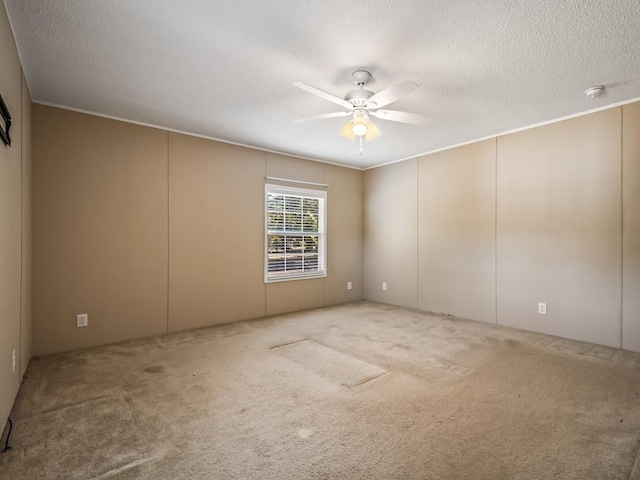 carpeted empty room featuring ceiling fan and a textured ceiling