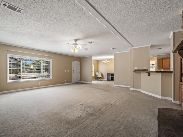 unfurnished living room featuring carpet floors, ceiling fan with notable chandelier, and a textured ceiling