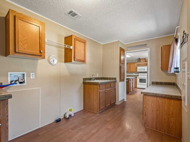 kitchen with sink, crown molding, light hardwood / wood-style flooring, a textured ceiling, and white appliances