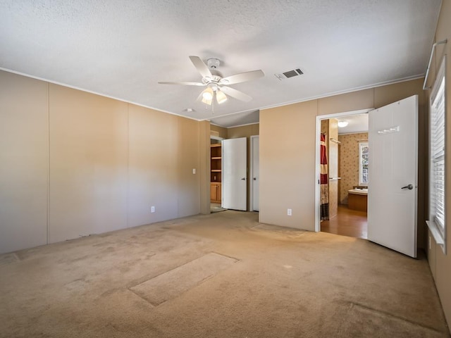 unfurnished bedroom with ceiling fan, connected bathroom, and carpet floors