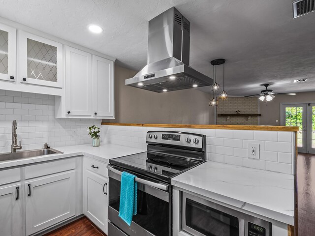 2600 Panther Creek Rd Unit A, Tallahassee, FL 32308 - kitchen with electric range, island range hood, white cabinets, tasteful backsplash, and recessed lighting