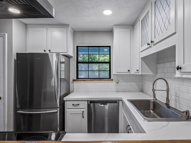 2600 Panther Creek Rd Unit A, Tallahassee, FL 32308 - kitchen with appliances with stainless steel finishes, exhaust hood, white cabinetry, tasteful backsplash, and light stone countertops