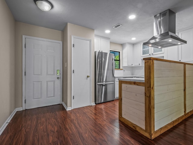 2600 Panther Creek Rd Unit A, Tallahassee, FL 32308 - kitchen with freestanding refrigerator, island exhaust hood, dark wood-style floors, white cabinetry, and light countertops