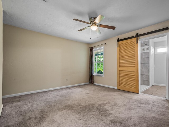 2600 Panther Creek Rd Unit A, Tallahassee, FL 32308 - unfurnished bedroom with carpet, a barn door, and a ceiling fan