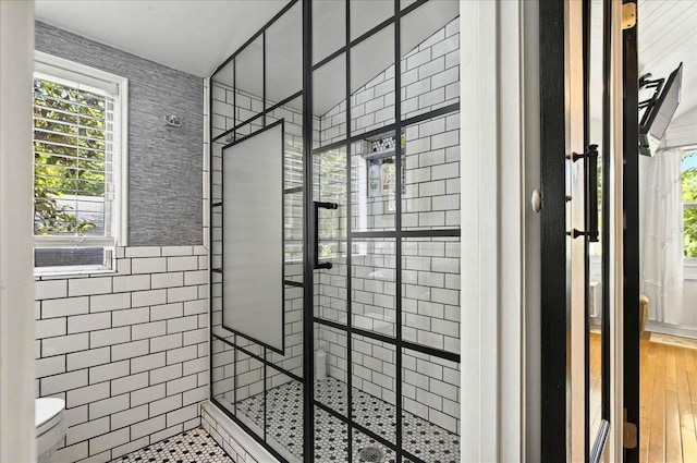 1645 Tallavana Trl, Havana, FL 32333 - full bath featuring a tile shower, healthy amount of natural light, toilet, wood finished floors, and tile walls