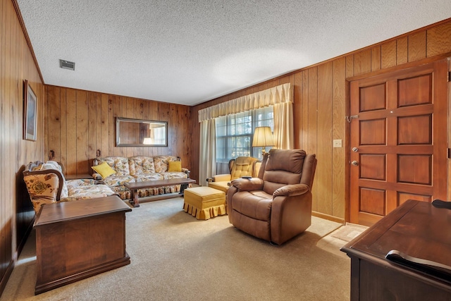 living room with wood walls, a textured ceiling, and light carpet