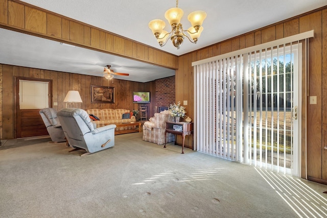 carpeted living room featuring ceiling fan with notable chandelier