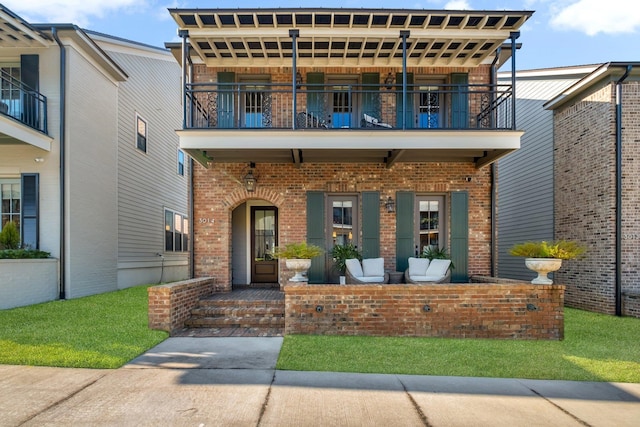 view of front of property featuring a front yard and a balcony