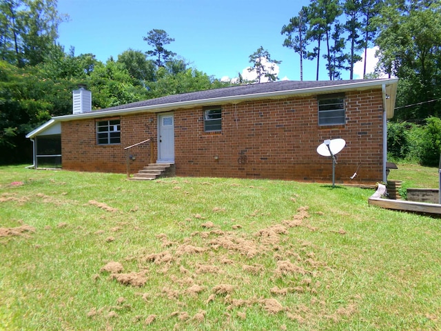 402 W Brent St, Chattahoochee, FL 32324 - rear view of property featuring entry steps, a chimney, a lawn, and brick siding
