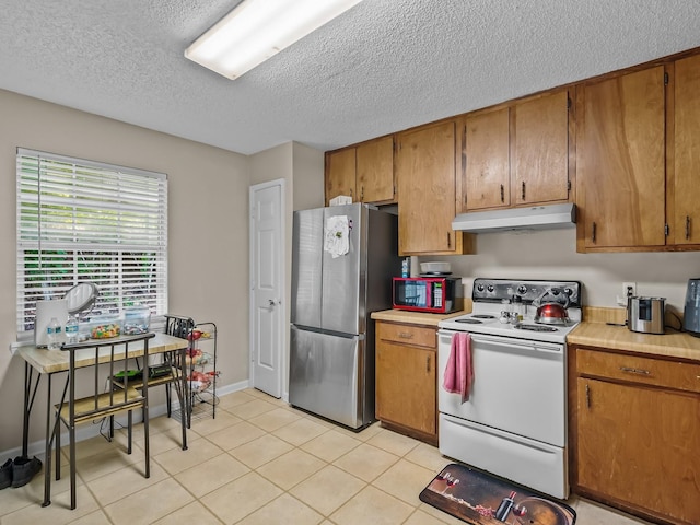 2390 Gregory Dr, Tallahassee, FL 32303 - kitchen with white range with electric stovetop, freestanding refrigerator, under cabinet range hood, light countertops, and a textured ceiling