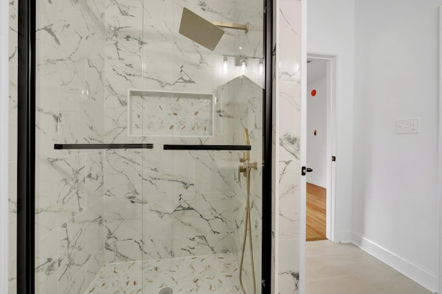 bathroom with a shower with door and tile patterned flooring