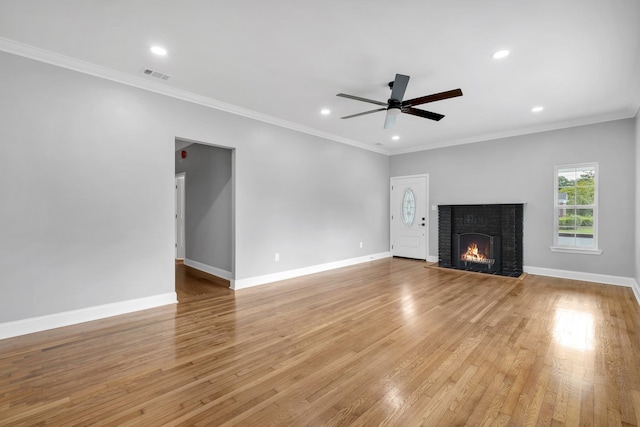 unfurnished living room featuring a fireplace, ceiling fan, light hardwood / wood-style flooring, and crown molding