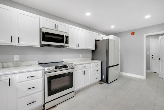 502 N 11th St, Quincy, FL 32351 - kitchen with stainless steel appliances, white cabinets, recessed lighting, baseboards, and light stone countertops