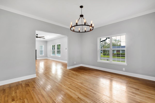 spare room featuring ornamental molding, ceiling fan with notable chandelier, and light hardwood / wood-style flooring