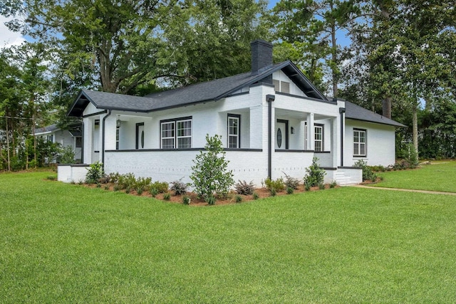 502 N 11th St, Quincy, FL 32351 - view of property exterior featuring a chimney, a lawn, covered porch, and roof with shingles